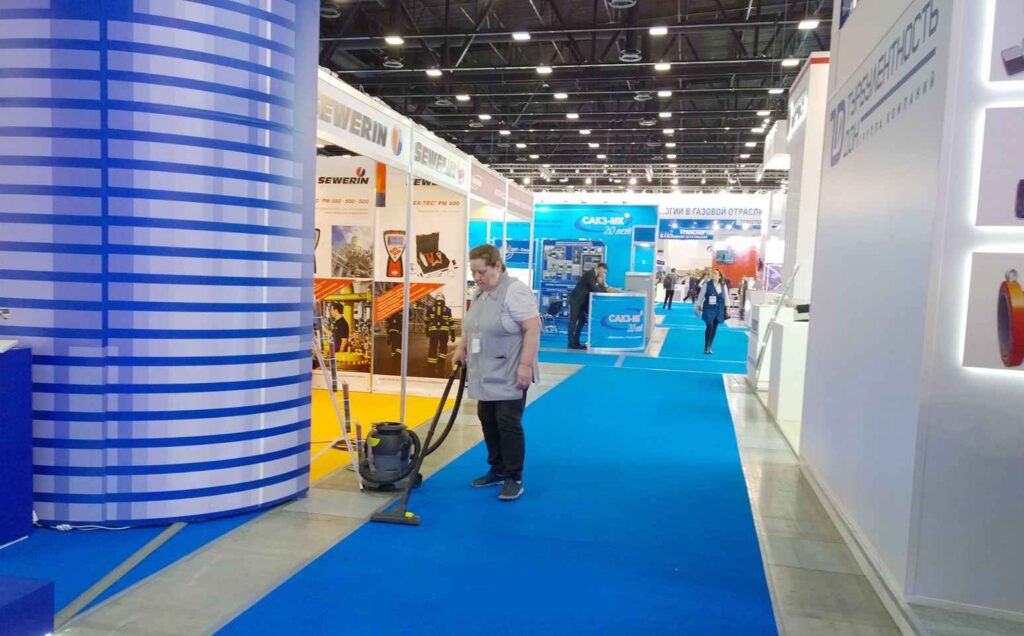 Active cleaner vacuuming carpet floor in the event spaces