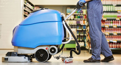 Cleaner scrubbing floors on shopping center