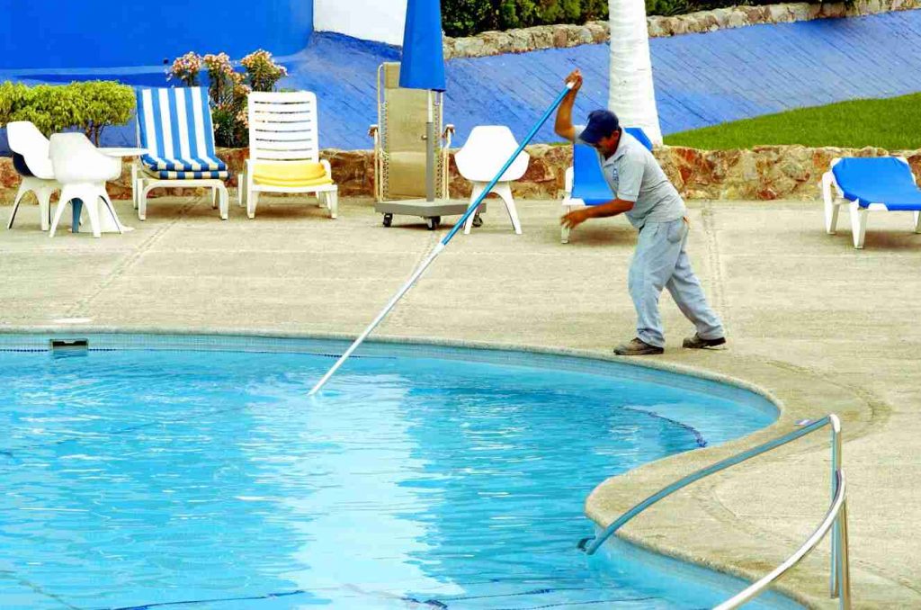 Cleaner removing floating leaves in swimming pool