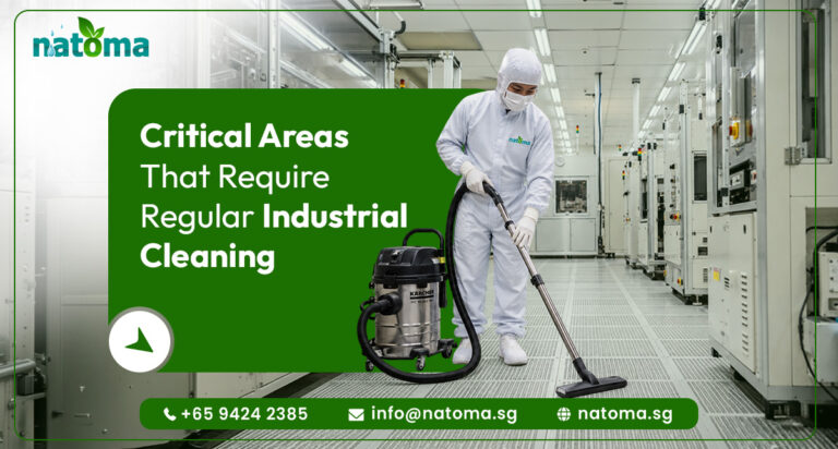 Natoma, an industrial cleaning service. A worker in a white full-body protective suit and face mask is using a industrial vacuum cleaner on a white raised floor in a clean the room or high-tech manufacturing facility.